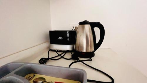 a coffee maker sitting on a counter next to a sink at Oasis Suits DHA in Lahore