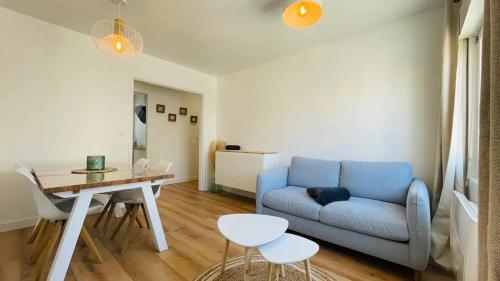 un salon avec un canapé bleu et une table dans l'établissement PAROGA appartement à 100m de la plage, à Merlimont