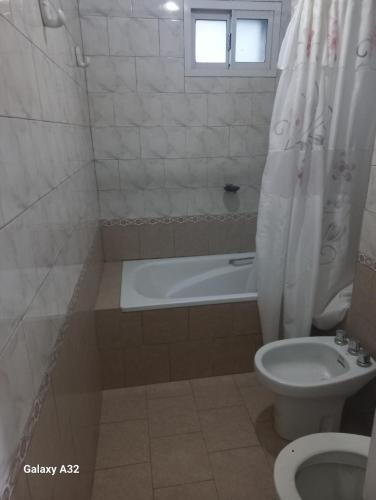 a bathroom with a tub and a toilet and a sink at Casa Quequen in Quequén