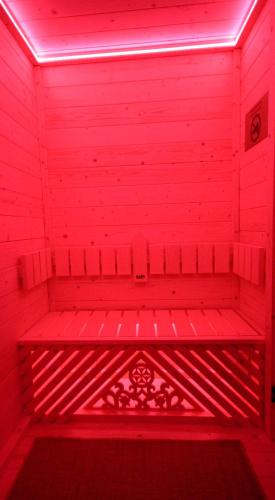 a red room with a bench in a red light at Dom Gościnny Borsuczyna in Wetlina