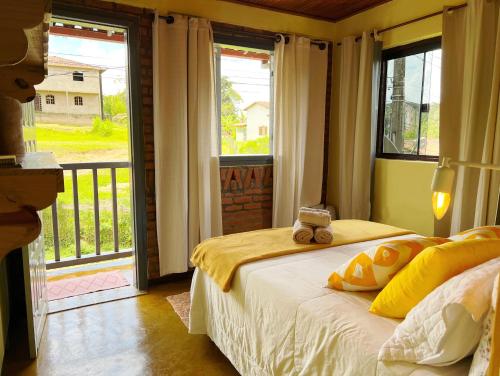 a bedroom with a bed with a teddy bear sitting on it at Cantinho da Neblina in Lavras Novas