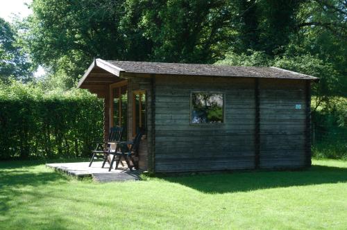 a small shed with a chair in the grass at Hotel Camping sur Yonne in Épiry
