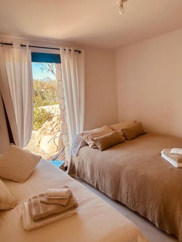 une chambre avec deux lits et une fenêtre dans l'établissement bergerie-ucaseddu, à Zonza