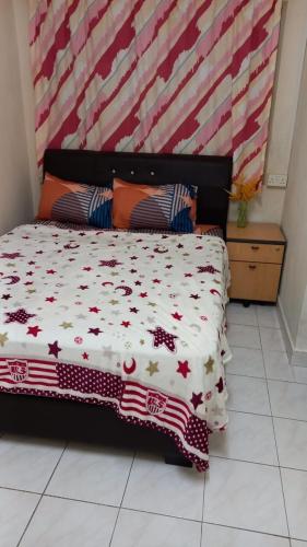 a bedroom with a bed with a red and white comforter at Bentong Hill Cottage in Bentong