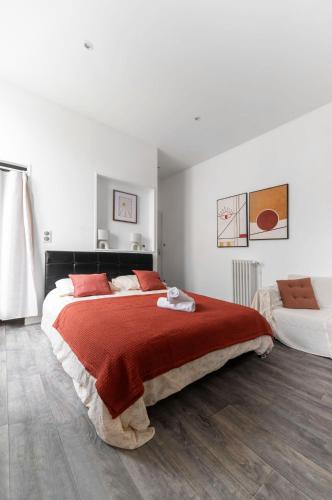 une chambre avec un grand lit avec une couverture rouge dans l'établissement Residence Germot - Maison et Appartements design proche Thermes, à Vichy