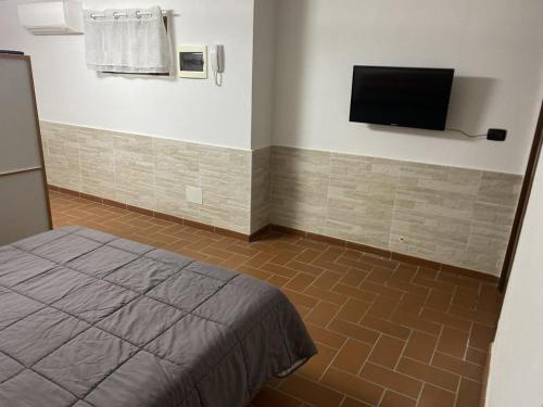 Un dormitorio con una cama y un televisor de pantalla plana. en Lacro Home, en Rosignano Solvay