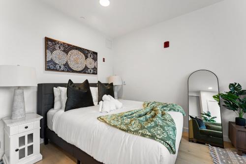 a bedroom with a large white bed with black pillows at Furnished Apartment in South Boston in Boston