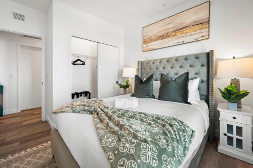 a bedroom with a large bed with a green and white comforter at Luxury Furnished Apartment Near Logan Airport in Boston