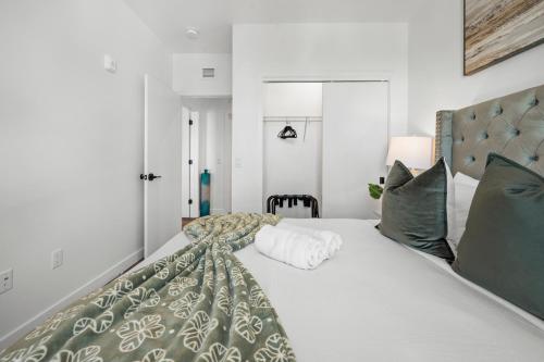 a bedroom with a large white bed with green pillows at Luxury Furnished Apartment Near Logan Airport in Boston