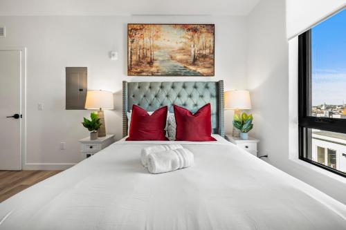 ボストンにあるLuxury Furnished Apartment Near Logan Airportの赤い枕が付いた大きな白いベッドのある寝室
