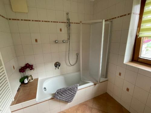 a bath tub in a bathroom with a shower at Brunnerhof in Strassen
