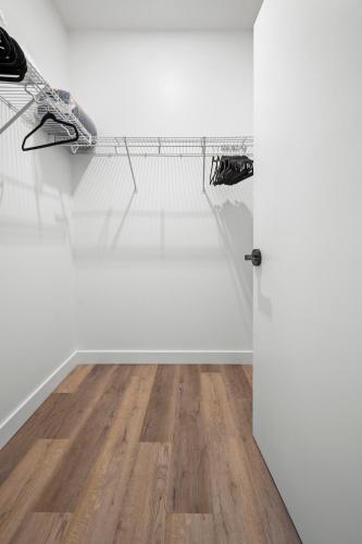 a room with a white wall and a wooden floor at Luxury Furnished Apartment Near Logan Airport in Boston