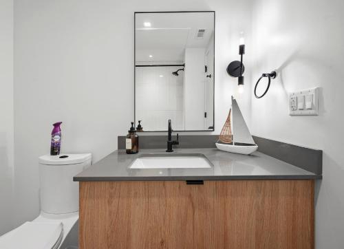 a bathroom with a sink and a mirror at Luxury Furnished Apartment Near Logan Airport in Boston
