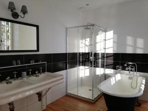 une salle de bain avec deux lavabos et une douche en verre dans l'établissement Domaine Abartiague, à Ossès