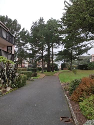 une passerelle devant une maison arborée dans l'établissement appartement proche plage avec piscine, à La Baule