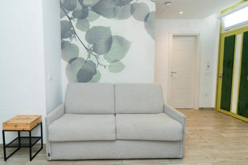 a couch in a living room with a flower mural on the wall at Vesuvio Inn Bed & Wine Experience in Boscotrecase