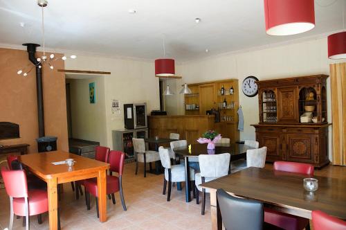a dining room with tables and chairs and a clock at Hotel Camping sur Yonne in Épiry