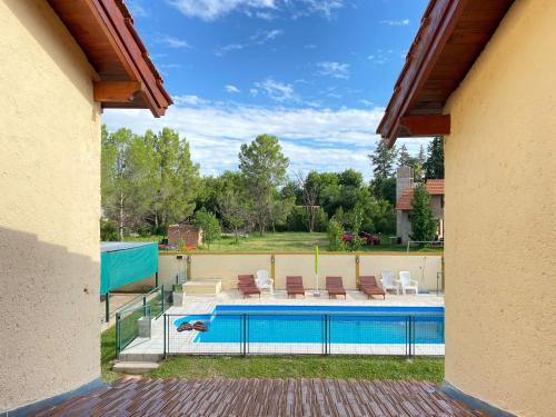 una piscina en un patio trasero con sillas en Cabañas Amore Mío, en Mina Clavero