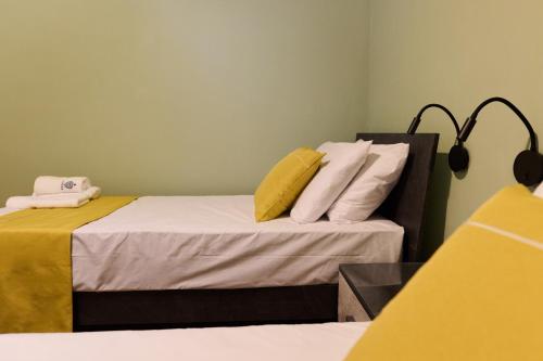a bedroom with two beds with yellow and white pillows at Galea Hospitality - Caravaggio in Xagħra