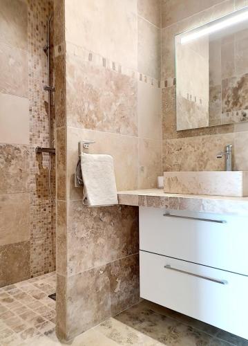 une salle de bain avec un lavabo et un miroir dans l'établissement Bas de villa contemporaine avec vue dégagée, à Alata