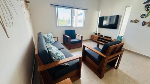 un soggiorno con due sedie e una TV di Punta Popy Beach Apartment a Las Terrenas