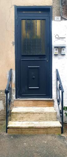 a black door with stairs in front of a building at NEpicentro in Nepi