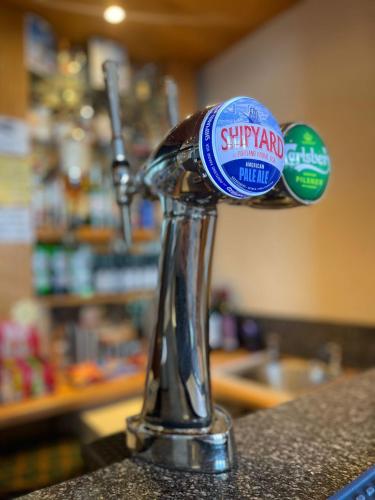 a metal faucet with stickers on top of a counter at Four Saints Brig Y Don Hotel in Llandudno