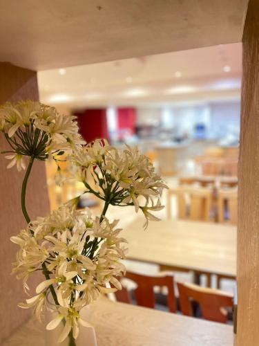 a vase filled with white flowers sitting on a table at Four Saints Brig Y Don Hotel in Llandudno