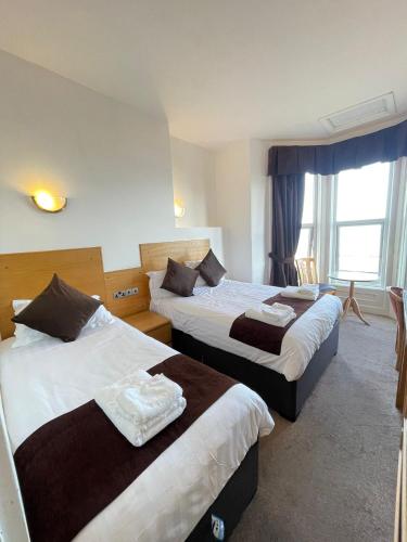 a hotel room with two beds and a window at Four Saints Brig Y Don Hotel in Llandudno