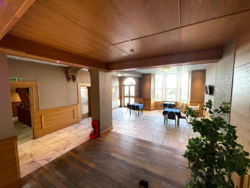 an empty room with tables and chairs in a building at Four Saints Brig Y Don Hotel in Llandudno