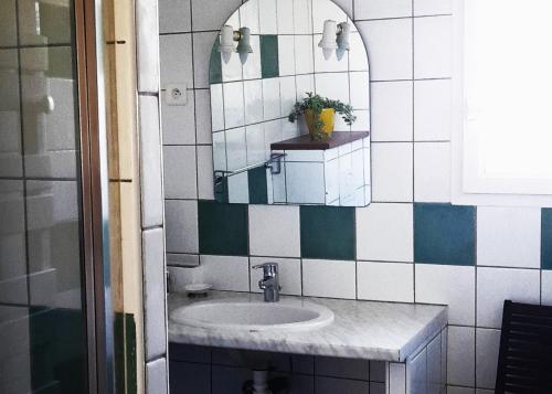 une salle de bain avec un lavabo et un miroir dans l'établissement Résidence Les Salettes, à Mormoiron