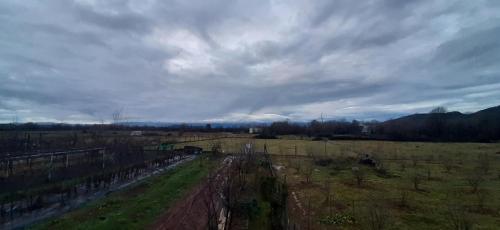 an aerial view of a field with a cloudy sky at Orchard Guard Tower in Ivanaj