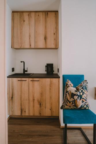 a kitchen with a sink and a blue chair at Luisashaus in Tirolo