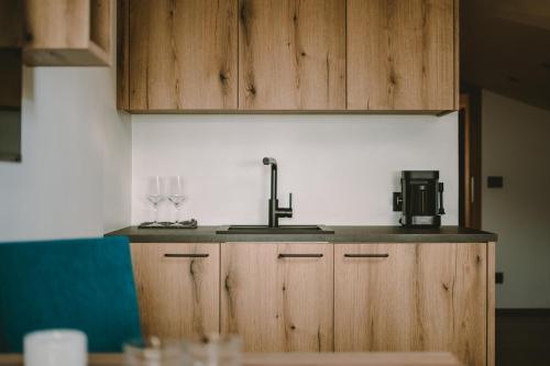 a kitchen with a sink and two wine glasses at Luisashaus in Tirolo