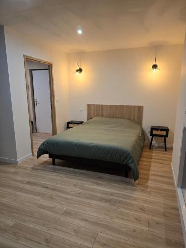 une chambre avec un lit et un parquet dans l'établissement Appartement cosy près de Sceneo et Auchan au dessus du fleuriste Bellafleur, à Longuenesse