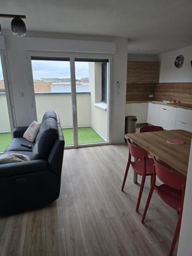 un salon avec un canapé et une table dans l'établissement Appartement cosy près de Sceneo et Auchan au dessus du fleuriste Bellafleur, à Longuenesse