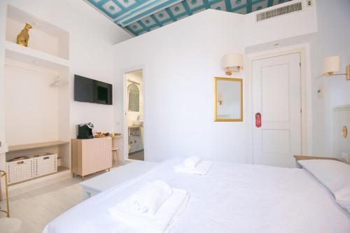 biała sypialnia z łóżkiem i kanapą w obiekcie Caffe' e Cuscino w Rzymie