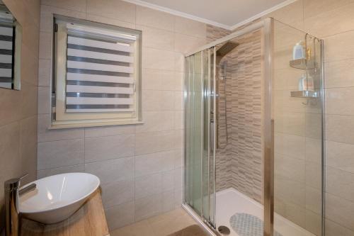 a bathroom with a glass shower and a sink at Villa Angela in Šmrika
