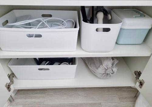 a shelf with white drawers in a room at Cozy Gangnam Jamsil KSPO DOM in Seoul