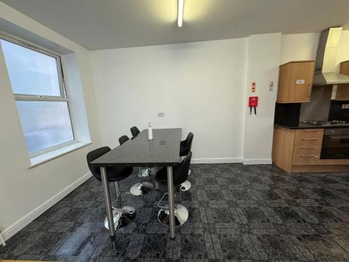 a room with a table and chairs in a kitchen at Sangha Hall in Leicester