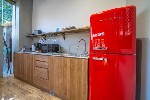 a red refrigerator in a kitchen with a sink at Komorebi Souseki 樹沐漱石 安平民宿 in Tainan
