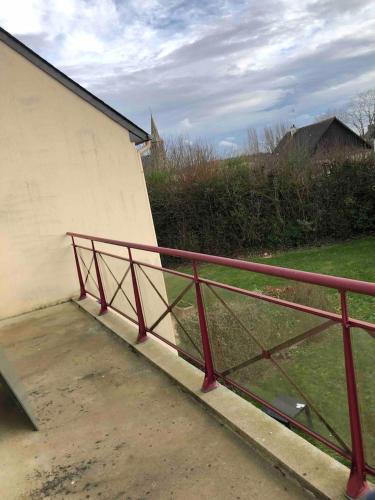 une rampe en métal rouge à côté d'un bâtiment dans l'établissement Appartement 2 pièces à Saint René, à Hillion