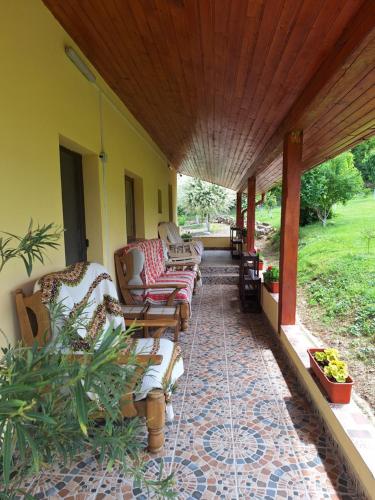 a porch with couches and chairs on a house at Casa Ciobanca in Vadul lui Carol II
