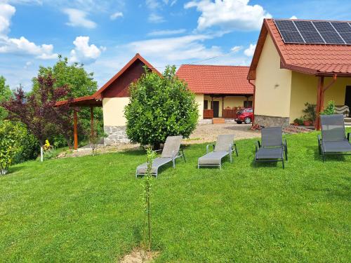 a yard with chairs and a house with solar panels at Casa Ciobanca in Vadul lui Carol II