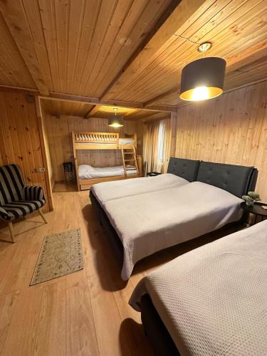a bedroom with two beds in a wooden cabin at კოტეჯი ბახმაროში WoodenHouse Sunrise in Bakhmaro