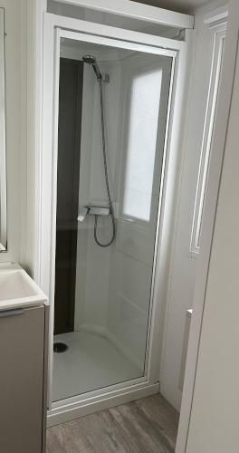 une douche avec une porte vitrée dans une salle de bain dans l'établissement Mobilhome Mag Ced les Dunes de contis Piscines et Plage, à Saint-Julien-en-Born