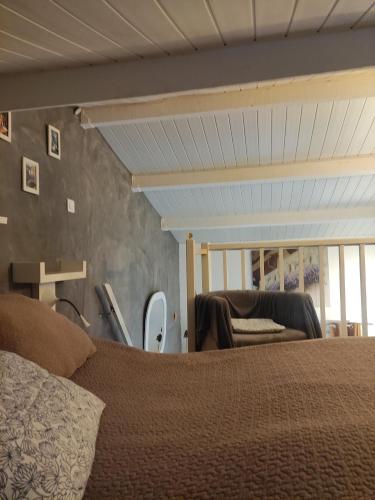 une chambre avec un lit et une chaise dans l'établissement bord de mer, à Cavalaire-sur-Mer