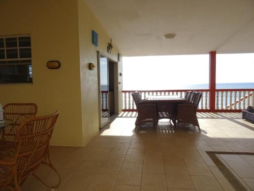 a dining room with a table and chairs on a balcony at Villa Tortuga Lagun in Lagun