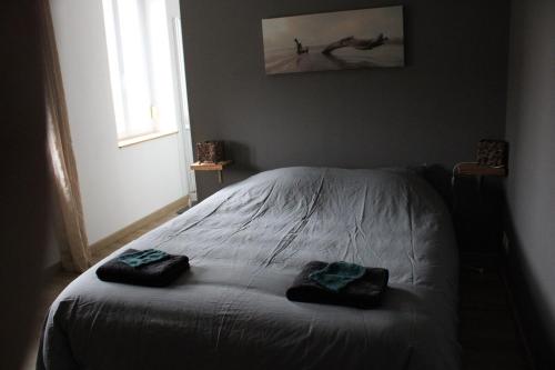 une chambre avec un lit avec deux serviettes dessus dans l'établissement Joli appartement Bethune à 2 pas de la gare, à Béthune