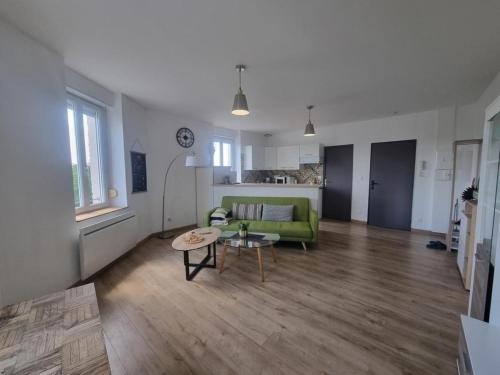un salon avec un canapé vert et une table dans l'établissement Joli appartement Bethune à 2 pas de la gare, à Béthune